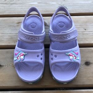 Crocs C13 lavender unicorn sandals.